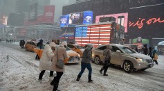 Pedestrians cope with snow covering sidewalks and streets in Time Square on January 23, 2016 in New York City.