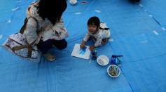 A Japanese child writes art as massage for light it up blue campaign for world Autism Awareness Day on April 2, 2015 in Himeji, Japan.