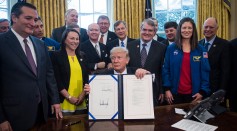 President Donald Trump holds up a bill to increase NASA's budget to $19.5 billion and directs the agency to focus human exploration of deep space and Mars after signing on Tuesday, March. 21, 2017.