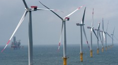 Wind turbines stand at the nearly completed Riffgat offshore wind farm in the North Sea on June 23, 2013 near Borkum, Germany in front of the jack-up installation vessel 'Bold Tern'