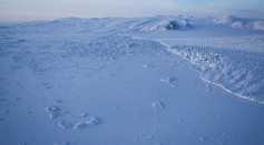 A glacier (R) and sea ice (L) are seen from NASA's Operation IceBridge research aircraft on March 30, 2017 above Ellesmere Island, Canada.