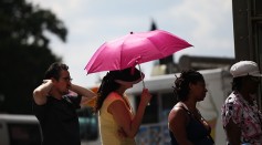 A woman holds an umbrella on a Manhattan street on one of the hottest days of the summer on July 20, 2015 in New York City