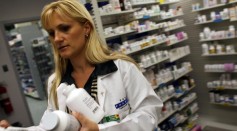 Roxana Selagea, a Publix Supermarket pharmacy manager, retrieves bottles of antibiotics from the shelf August 7, 2007 in Miami, Florida