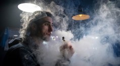 A smoker exhales the vapor from the e-cigarette product at a vaping shop in Bristol, England.