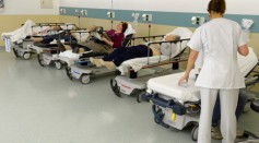 Patients lie in beds before treatment at the hospital.