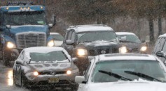 Vehicles cruise under light snowfall on Nov. 26, 2014 in Newark, NJ.
