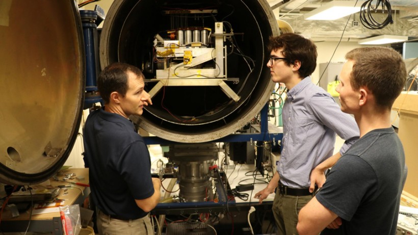 Associate Professor Joshua Rovey, left, talks about electric propulsion system testing with AE graduate students Nick Rasmont and Matt Klosterman