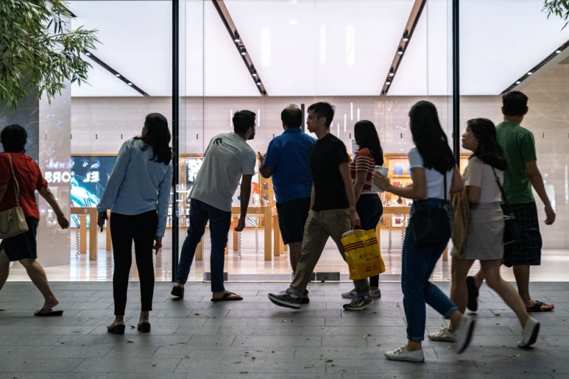 People looks into an empty flagship Apple retail store on Orchard Road on March 15, 2020 in Singapore. 