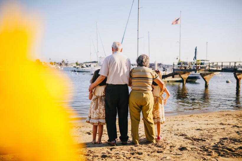 grandparents-with-their-granddaughters-standing-by-the-shore-5637770