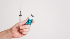 person-holding-syringe-and-vaccine-bottle-3952241