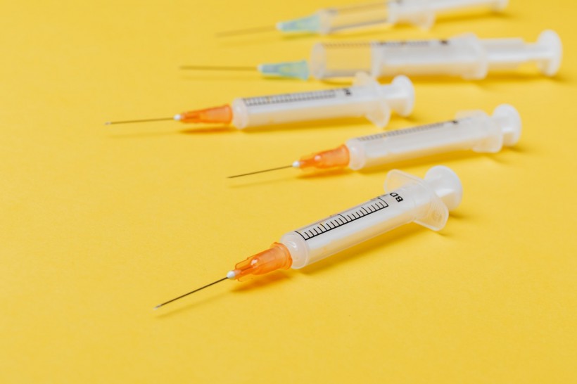 syringe-injectors-placed-on-yellow-surface-4210559