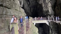 Tourists pass over a bridge above where the Qing River flows through Tenglong Cave, near Lichuan in China's Enshi prefecture.