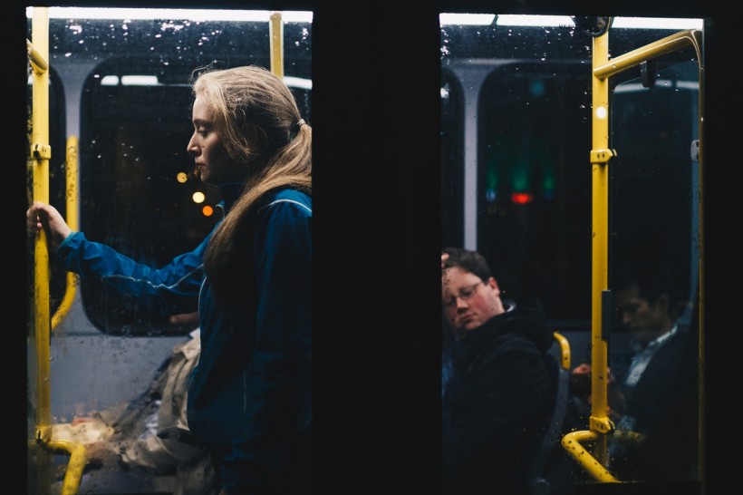 Photo of a Lonely Woman Standing Inside Bus