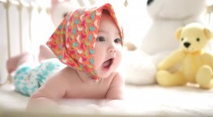 Toddler Wearing Head Scarf in Bed