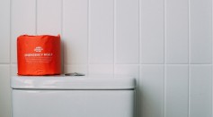 Red Toilet Paper on White Ceramic Toilet