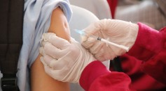 A student is being injected with a vaccine