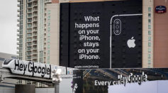 A monorail train displaying Google signage moves past a billboard advertising Apple iPhone security during the 2019 Consumer Electronics Show (CES) in Las Vegas, Nevada, U.S.
