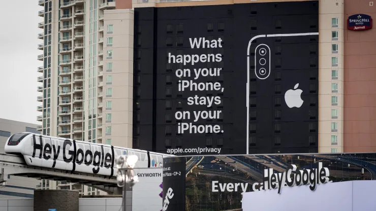 A monorail train displaying Google signage moves past a billboard advertising Apple iPhone security during the 2019 Consumer Electronics Show (CES) in Las Vegas, Nevada, U.S.