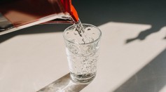 Pitcher pouring water in a glass - stock photo