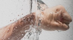 Person's Left Fist Punching Water