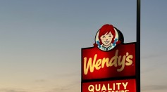 a sign for wendy's restaurant in a parking lot