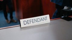  a desk with a sign on it that says defendant