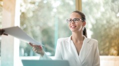 Positive businesswoman doing paperwork in office