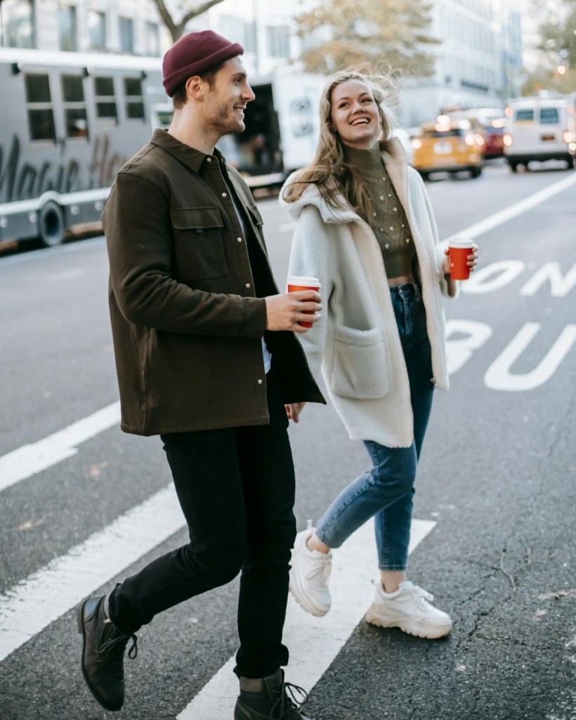 Couple walking on street with coffee cups