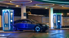 a blue car parked in front of a gas station