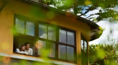 Long shot of couple looking out the window of their new house