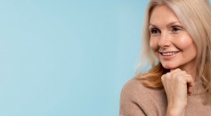 Senior woman posing and smiling against a blue background