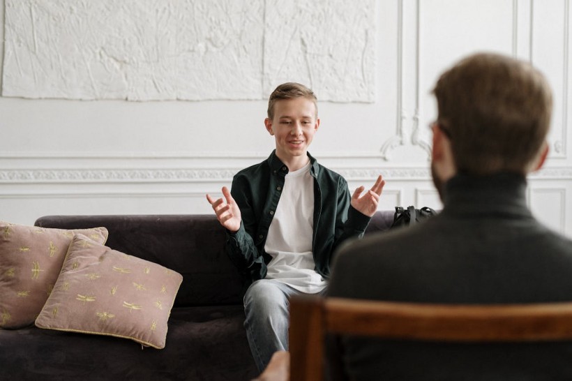 A man sitting on a couch in front of another person