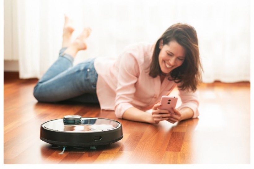 woman with a robotic vacuum cleaner