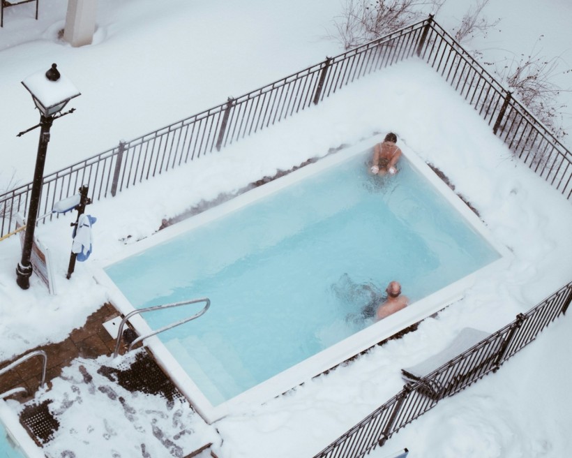 a couple of people in a swimming pool covered in snow