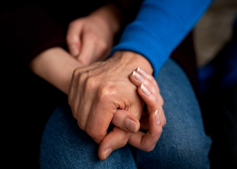 Hands holding each other for support