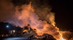 A Chinese labourer pours steel as fire is seen in a cooling pit at an unauthorized steel factory on November 3, 2016 in Inner Mongolia, China.