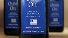 Bottles of imported Greek olive oil with 'Product of Greece' info displayed on their labels are seen on a shelf at the Greek Columbus Foods market January 14, 2005 in Des Plaines, Illinois. 