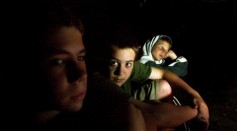Students sit by the fire while camping out at the Center for Attention and Related Disorders (C.A.R.D.) camp at the Great Hollow Wilderness School July 30, 2003 in New Fairfield, Connecticut.