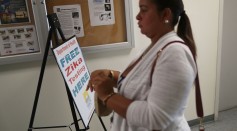 Krystal Cruz, who is pregnant, carries her urine sample as she gets a free Zika test from the Florida Department of Health that has setup a temporary clinic at the Miami Beach Police Department.