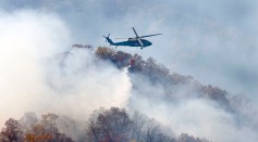 A Kentucky National Guard Blackhawk helicopter drops 660 gallons of water over a forest fire on Thursday, Nov. 17, 2016 in Letcher County, KY. 