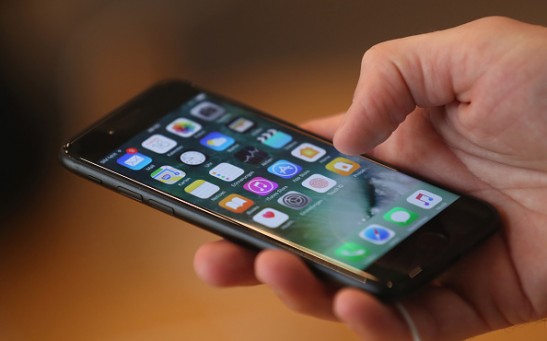 A visitor tries out an Apple iPhone 7 on the first day of sales of the new phone at the Berlin Apple store on September 16, 2016 in Berlin, Germany.