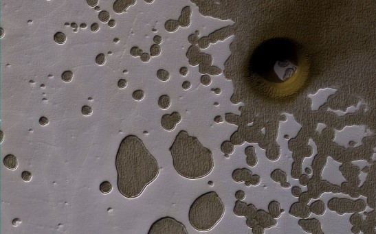 The latest image from NASA's Mars Reconnaissance Orbiter showing deep holes in the South Pole of Mars.