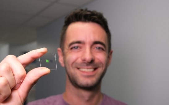 Dr. Alasdair Clark holding up a slide containing the materials that make up the artificial tongue.