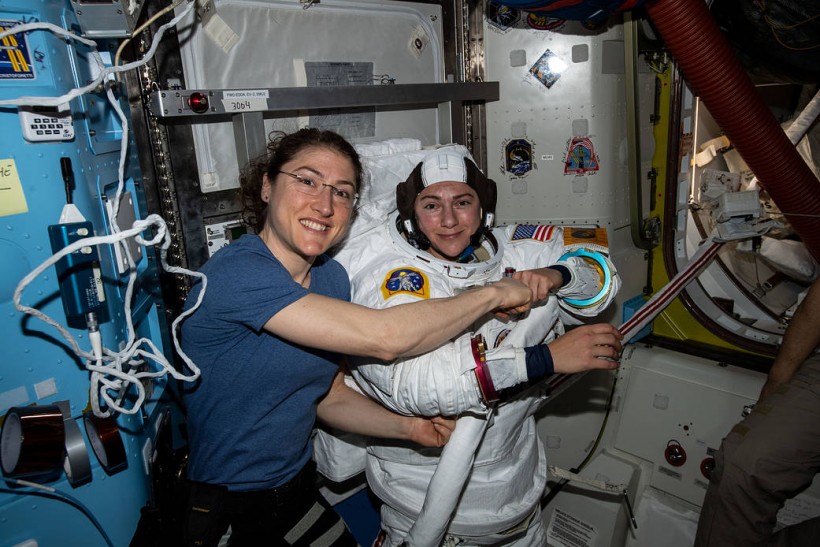 Expedition 61 Flight Engineers Christina Koch (left) poses for a photo with colleague Jessica Meir (right) while preparing for the first all-women spacewalk in history.