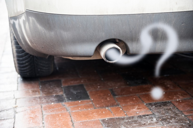 Exhaust from a car with diesel engine emitting gas in the shape of a question mark
