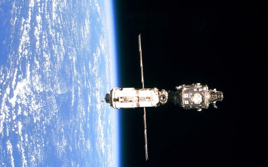 The International Space Station (Iss Is Backdropped Against The Blue And White Horizon Scene Of Earth)