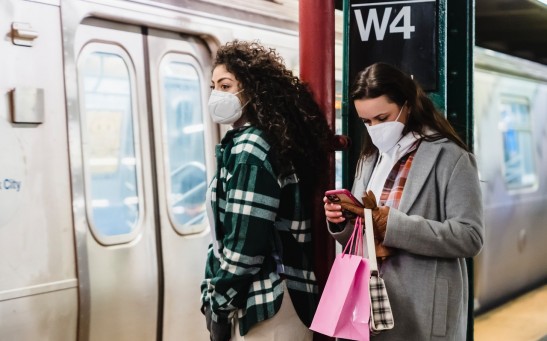 girlfriends-in-masks-using-cellphone-in-underground-station-near-train-6567595
