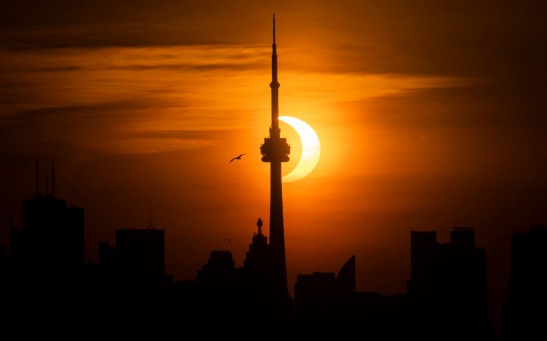 Rare Sunrise Eclipse Rises Beyond Toronto's CN Tower