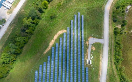 aerial-view-of-solar-panels-array-on-green-grass-2800845