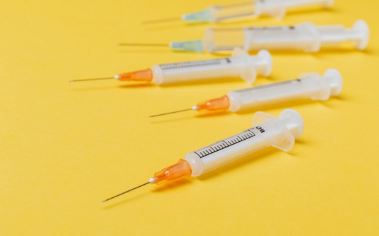 syringe-injectors-placed-on-yellow-surface-4210559